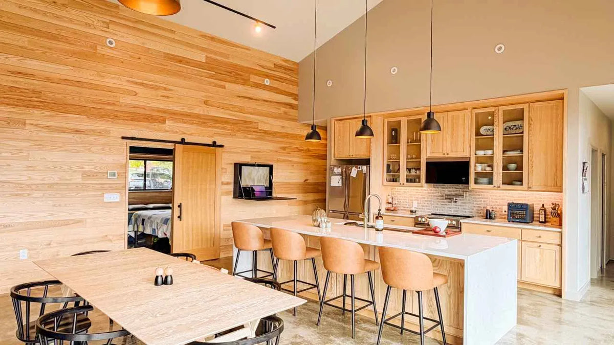 Open DropTop desk in a wood-paneled kitchen with an island and bar stools.