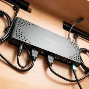 Docking station fixed inside the desk with several cables plugged in.
