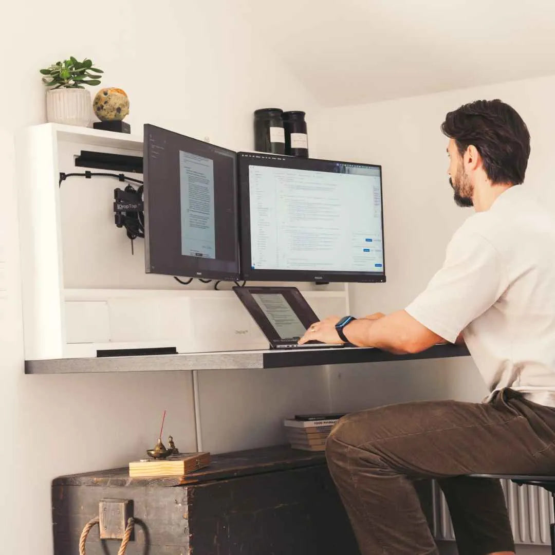 A DropTop Classic wall-mounted desk open with two monitors