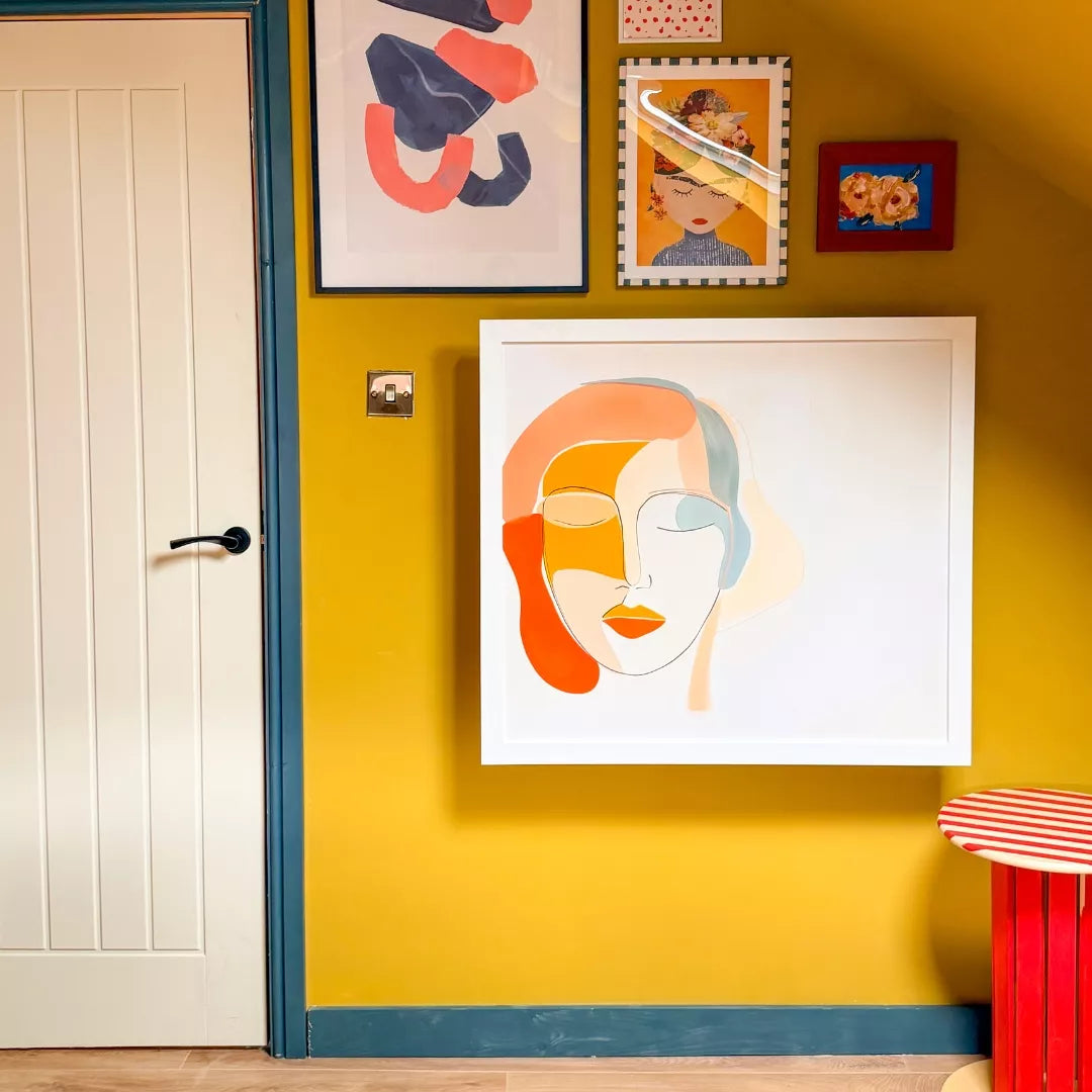Closed DropTop desk displaying a framed portrait print on a yellow wall.