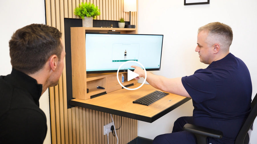 Two men looking at a monitor on an open DropTop desk.