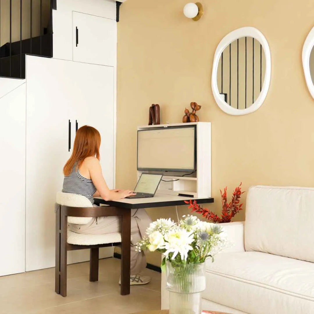 Woman working at an open DropTop desk in a bright living room.