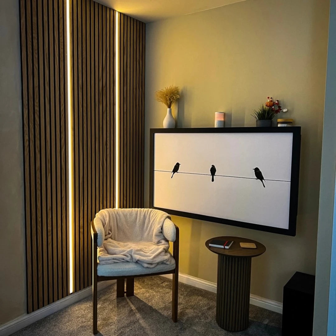 Closed DropTop desk showing a birds-on-a-wire print, beside a slatted, LED-lit feature wall.