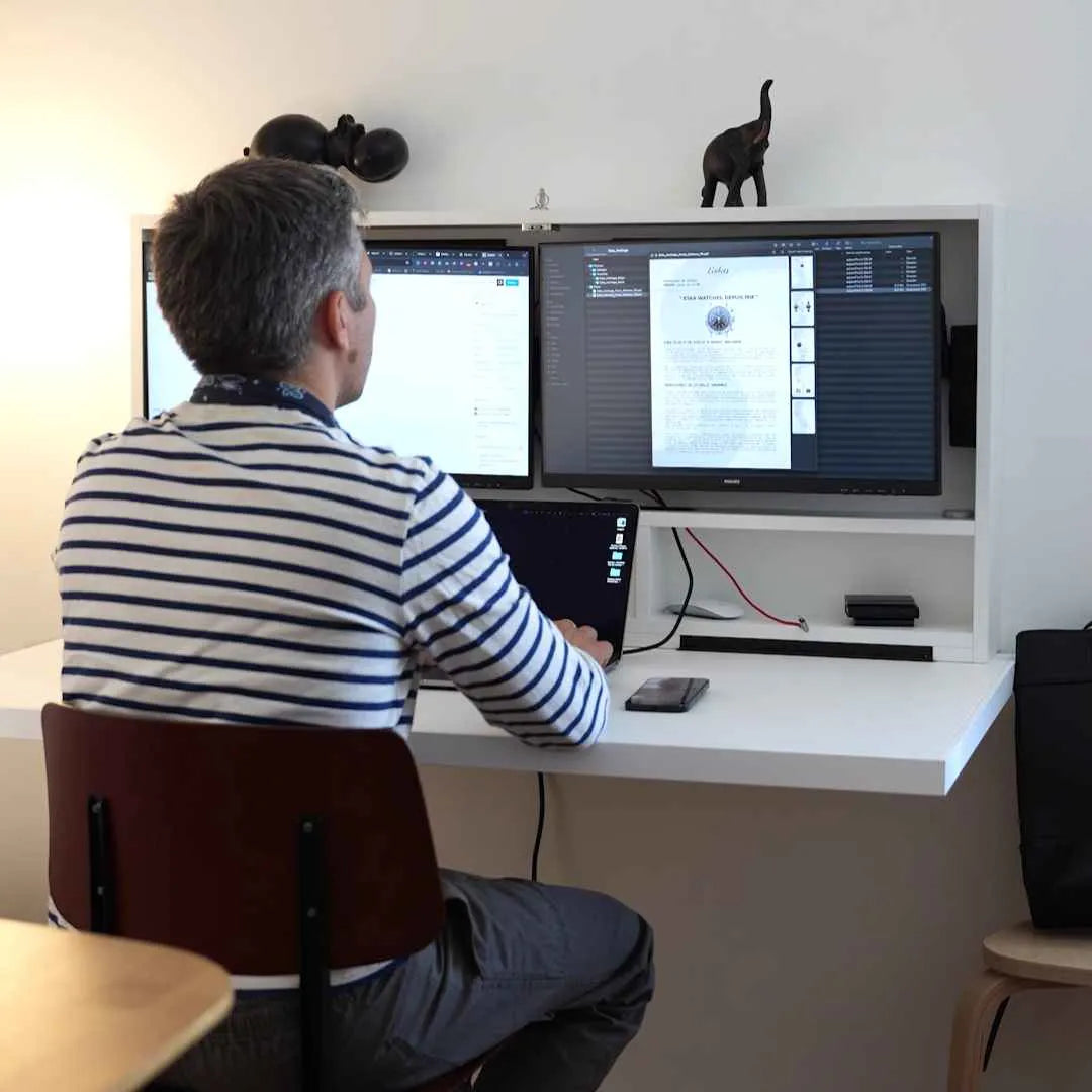Man working at an open white DropTop Duo 24 with two monitors of code and documents.