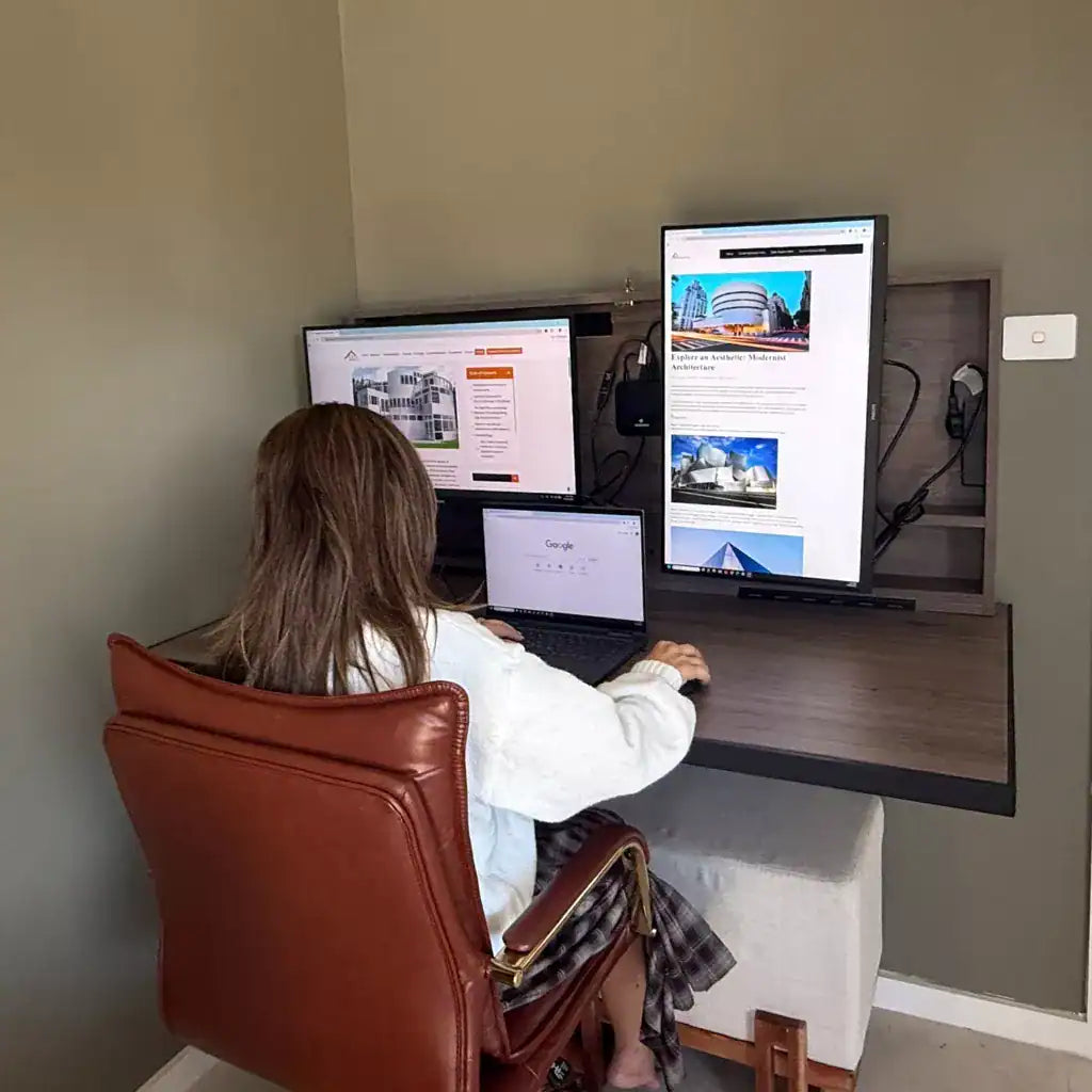 Woman typing at an open DropTop Duo 27 with two monitors and a laptop.