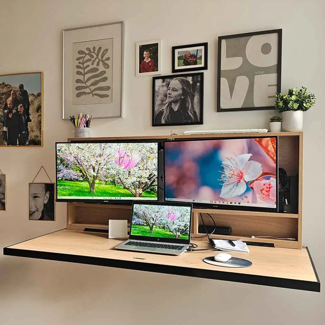 Open oak DropTop Duo 27 with two ultrawide monitors below a gallery wall of prints.