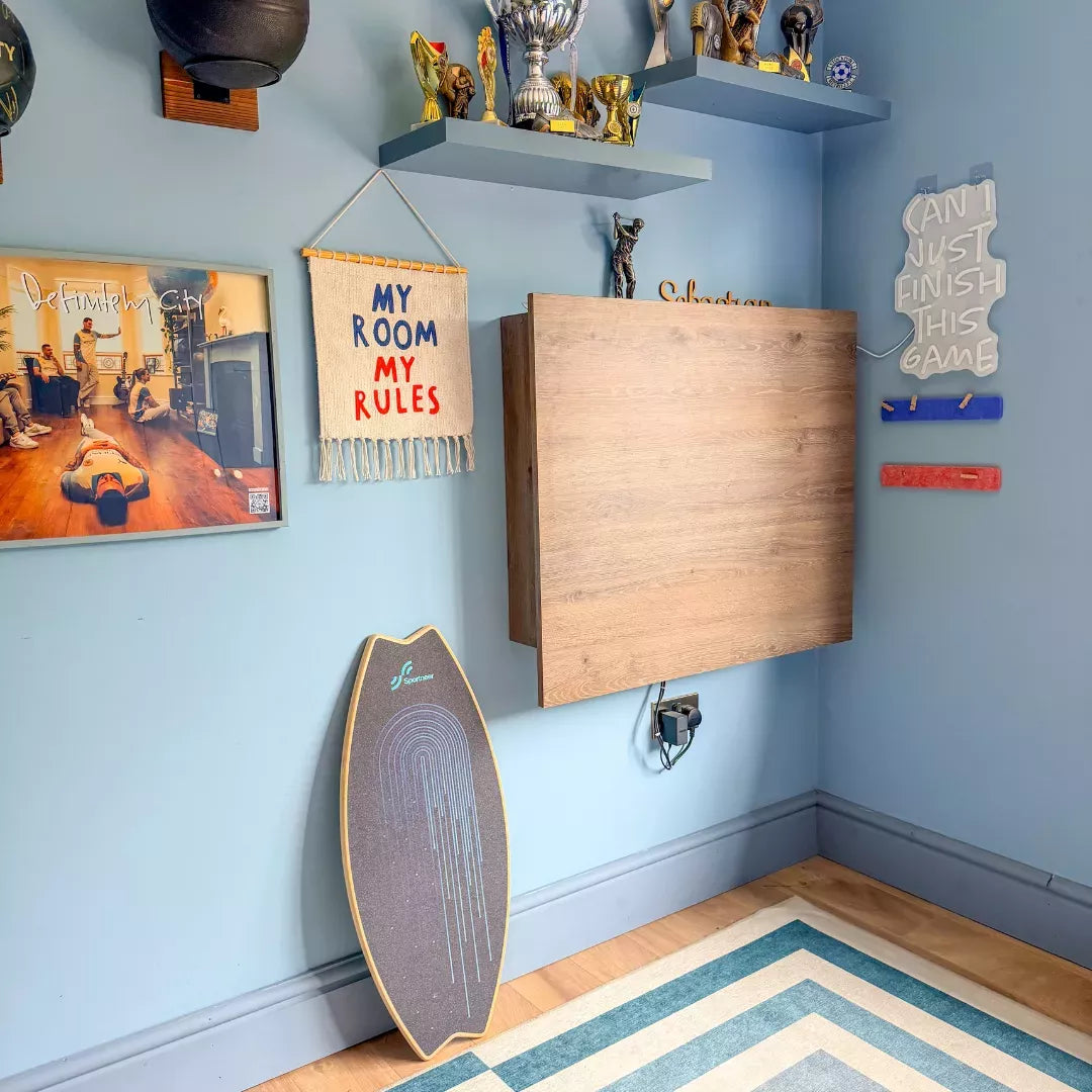 Closed oak DropTop desk in a teenager's bedroom with trophy shelves and posters.