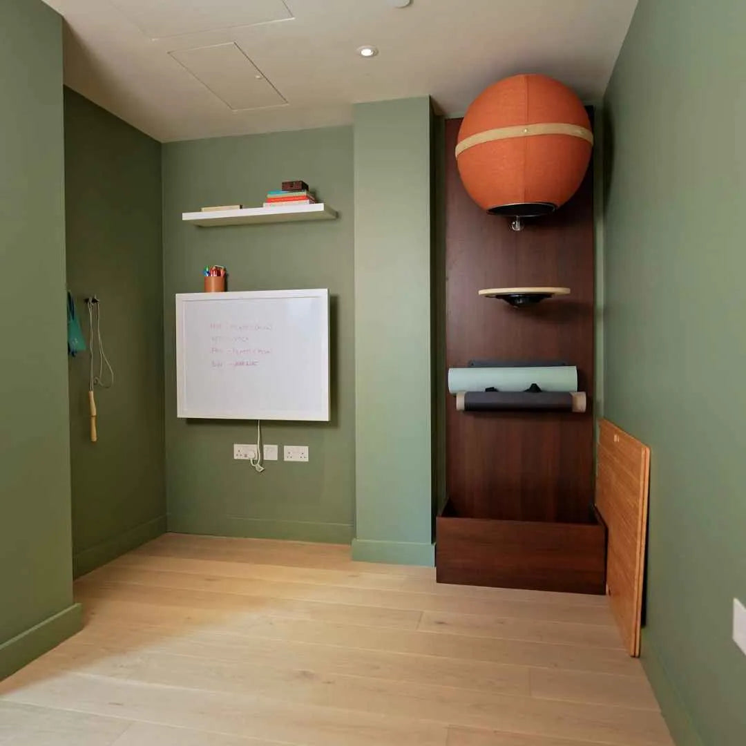 Closed walnut DropTop Single 29 with a whiteboard front in a green room.