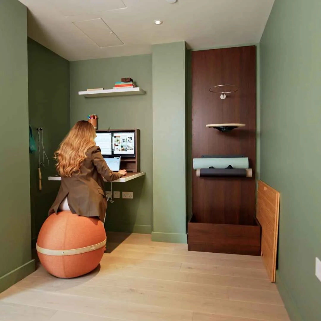 Woman working at an open walnut DropTop Single 29 while sitting on an exercise ball.