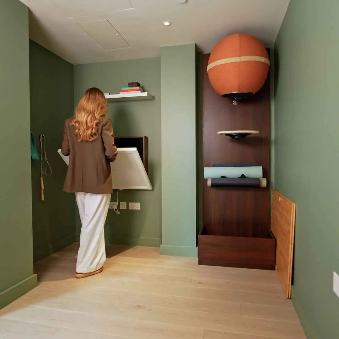 Woman pulling open a walnut DropTop Single 29 in a green room.
