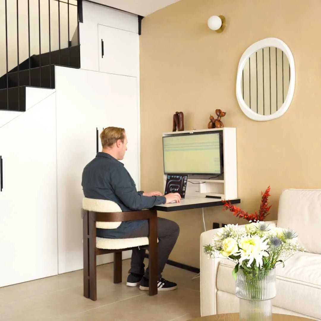 Man typing at an open white DropTop Single 34 fitted under a staircase.