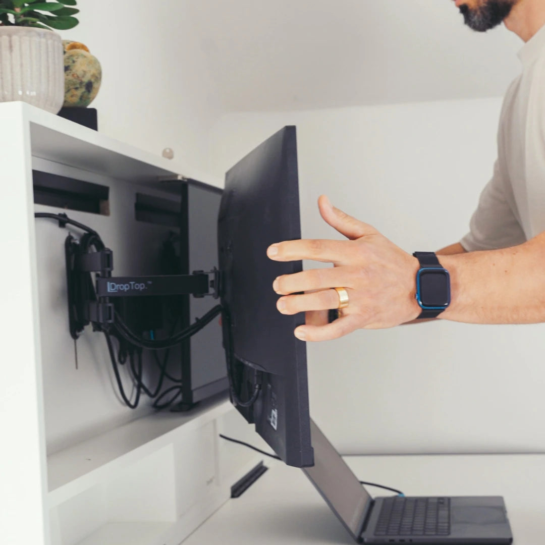 Hand pulling a monitor forward on a DropTop extendable monitor arm.